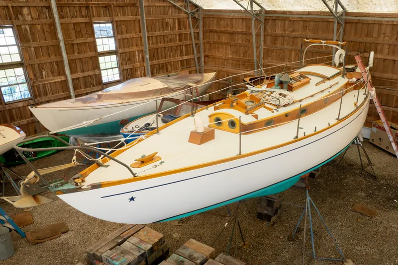 Slide: The Image of 1964 Concordia 39 sailboat in a wooden boathouse, elevated on stands. - 13