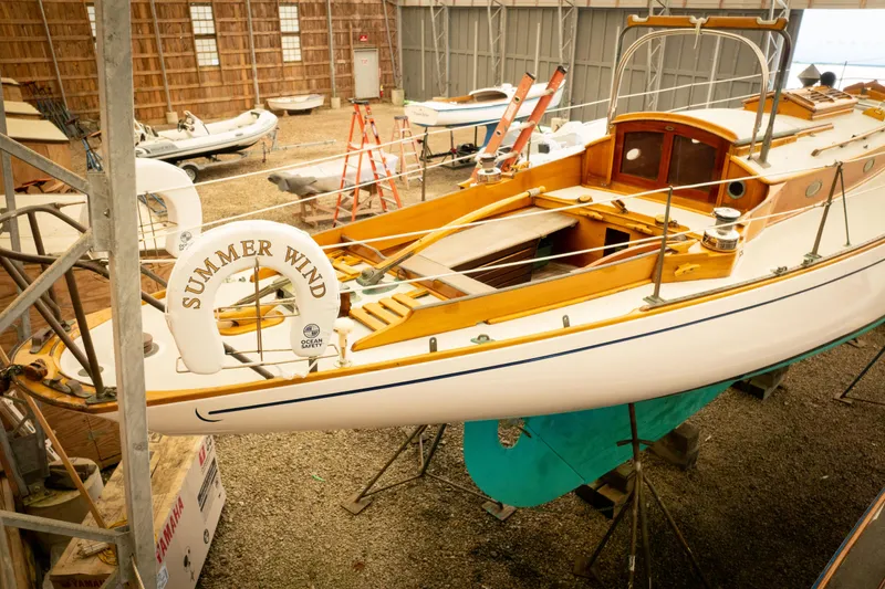 Slide: The Image of 1964 Concordia 39 sailboat "Summer Wind" in a boatyard, showcasing classic wooden design. - 17