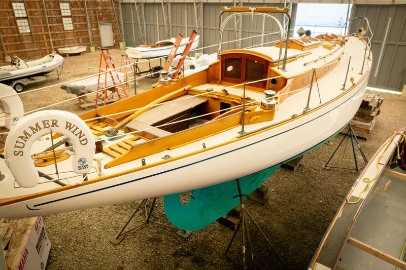 Slide: The Image of 1964 Concordia 39 sailboat "Summer Wind" in a boatyard, showcasing classic wooden design. - 20