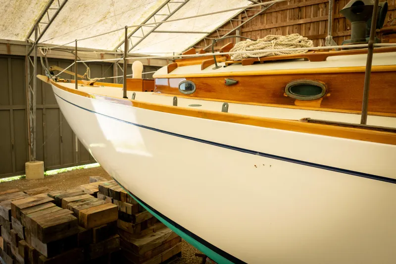 Slide: The Image of 1964 Concordia 39 sailboat in storage, showcasing classic wooden design and craftsmanship. - 21