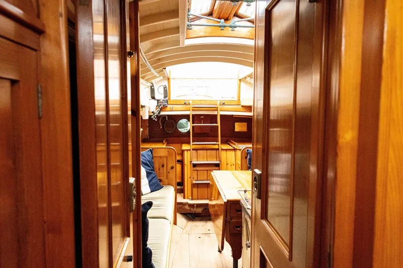 Slide: The Image of Interior of a 1964 Concordia 39 sailboat with wooden furnishings and cozy seating. - 23