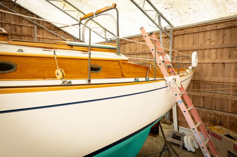 Slide: The Image of 1964 Concordia 39 sailboat in storage, wooden deck, ladder access, sheltered environment. - 24