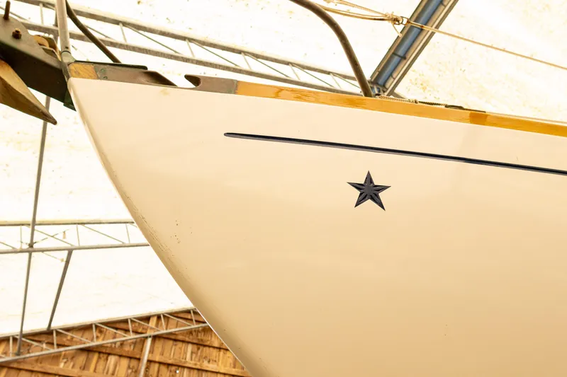Slide: The Image of Bow of 1964 Concordia 39 sailboat with star emblem in a covered area. - 27
