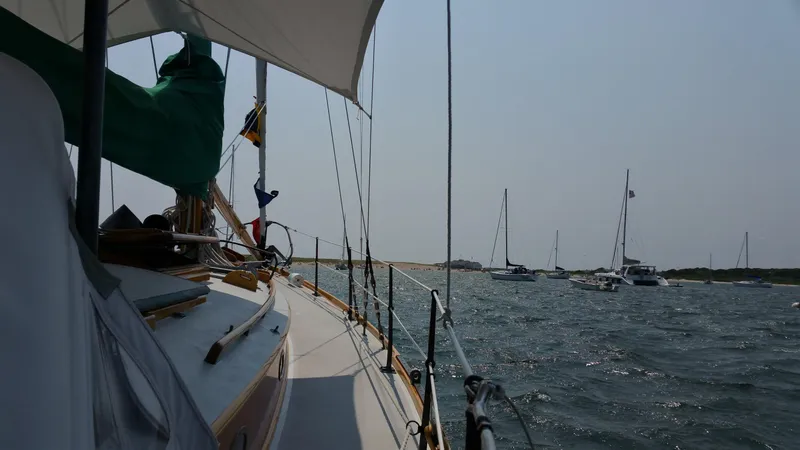 Slide: The Image of Sailing on a 1964 Concordia 39 yacht in a scenic harbor with other boats. - 29