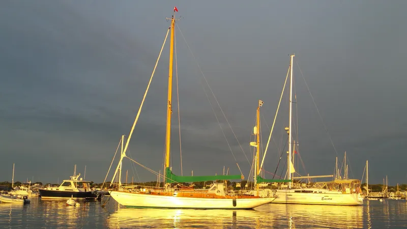 Slide: The Image of Sailboats anchored at sunset, featuring a 1964 Concordia 39. - 32
