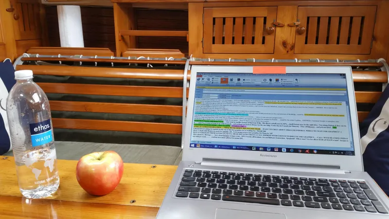 Slide: The Image of Laptop, apple, and water bottle on wooden table inside a 1964 Concordia 39 boat cabin. - 37
