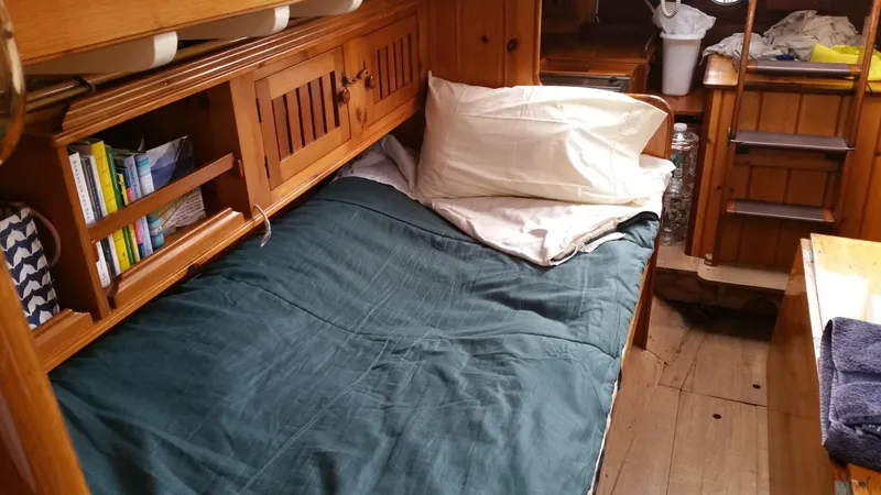 Slide: The Image of Cozy cabin interior of a 1964 Concordia 39 sailboat with wooden furnishings and a comfortable bed. - 40