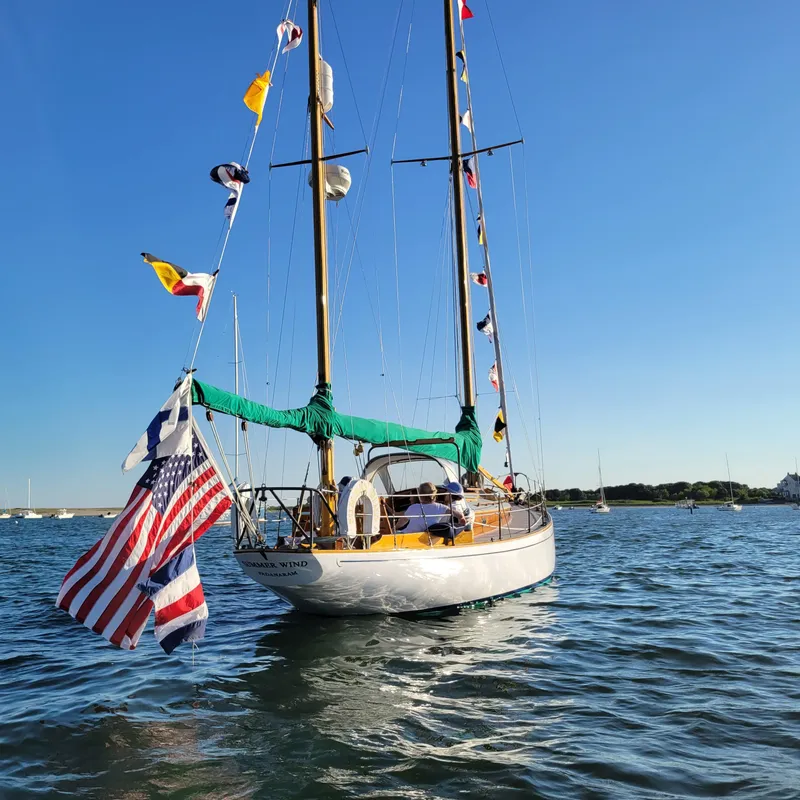 Slide: The Image of Sailboat Concordia 39 (1964) with flags and American flag on calm water. - 45