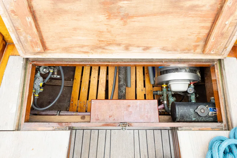 Slide: The Image of Engine compartment of a 1964 Concordia 39 sailboat, showing mechanical components and wooden structure. - 48