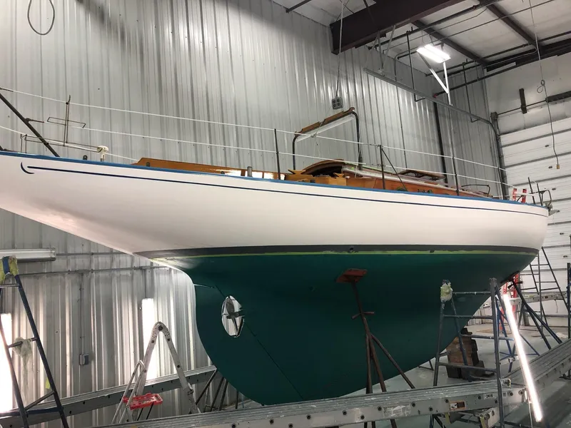 Slide: The Image of 1964 Concordia 39 sailboat in a workshop, elevated for maintenance. - 6