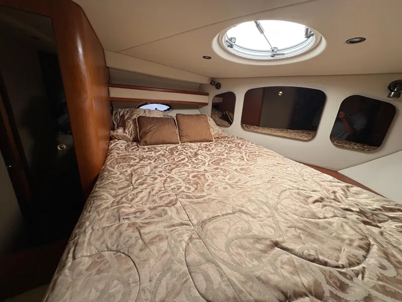 Slide: The Image of Luxurious cabin interior of 2001 Cruisers 3672 Express yacht with elegant bedding and porthole. - 11