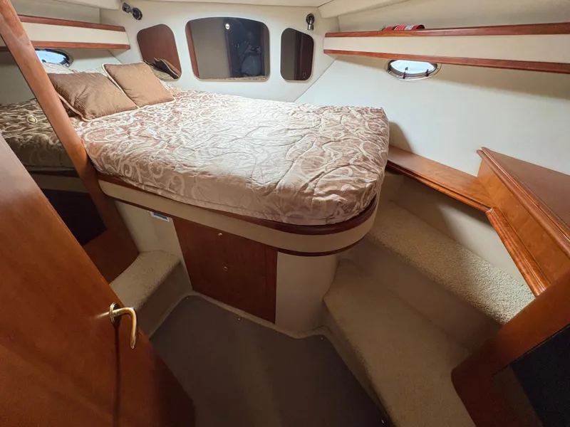 Slide: The Image of 2001 Cruisers 3672 Express cabin with bed, wooden accents, and carpeted steps. - 12
