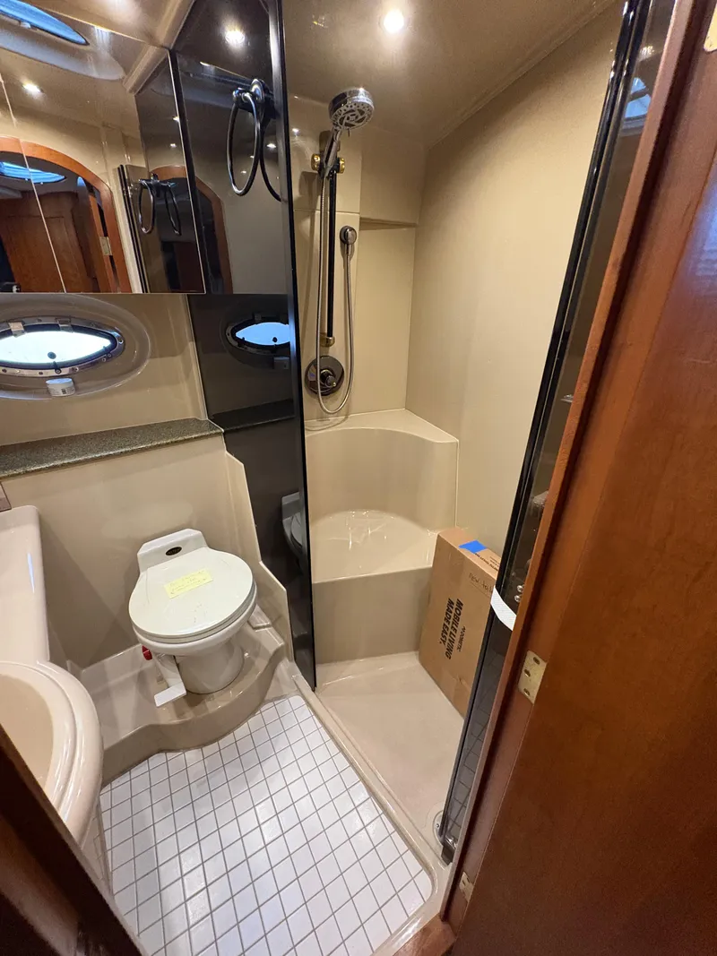 Slide: The Image of Bathroom interior of a 2001 Cruisers 3672 Express yacht, featuring a shower and toilet. - 13