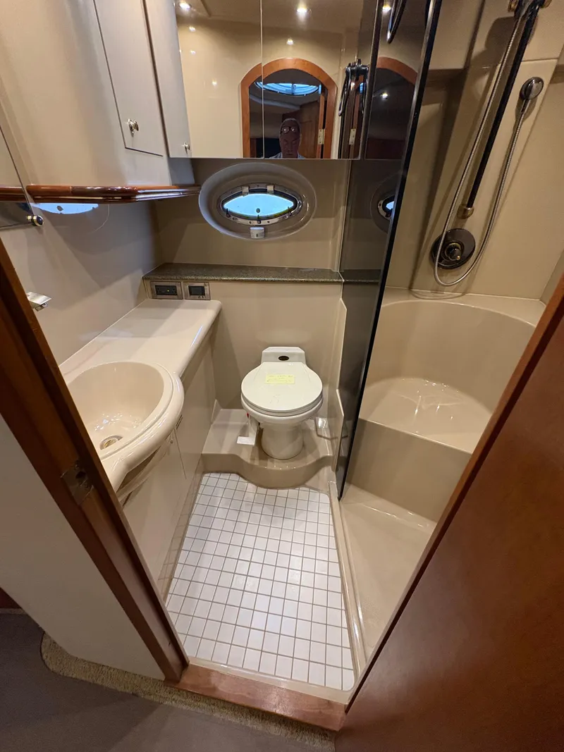 Slide: The Image of Bathroom interior of 2001 Cruisers 3672 Express yacht, featuring toilet, sink, and shower. - 14