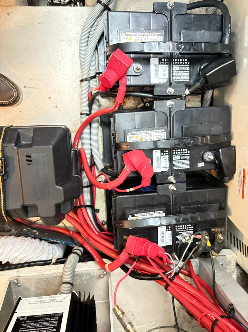 Slide: The Image of Battery setup in a 2001 Cruisers 3672 Express boat with red cables and connectors. - 17