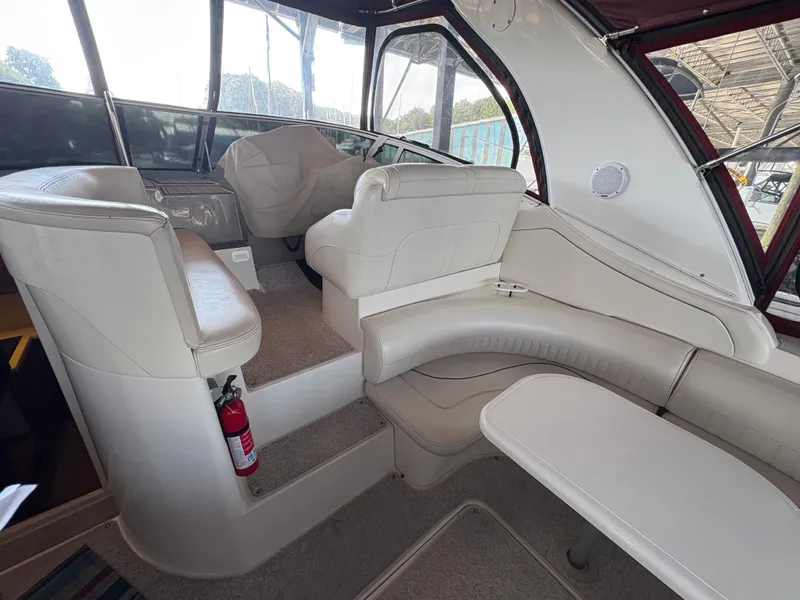 Slide: The Image of 2001 Cruisers 3672 Express interior with white leather seating and table, featuring a fire extinguisher. - 5