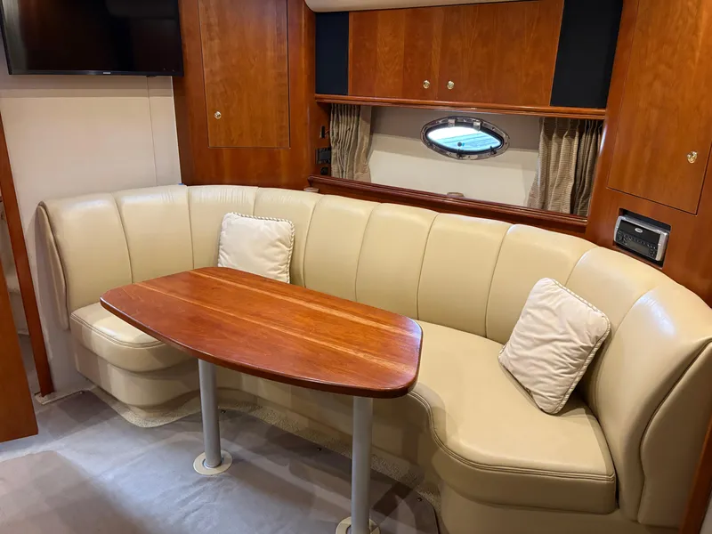 Slide: The Image of Luxurious 2001 Cruisers 3672 Express yacht interior with leather seating and wooden table. - 8