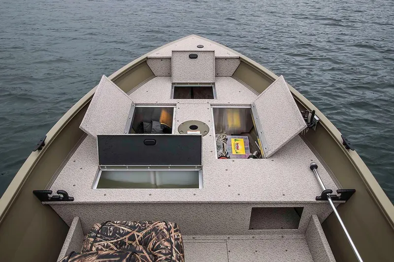 Slide: The Image of Manufacturer Provided Image: 2020 Crestliner 1450 Discovery Tiller boat with open storage compartments on the water. - 10