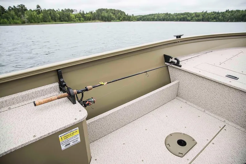 Slide: The Image of Manufacturer Provided Image: 2020 Crestliner 1450 Discovery Tiller boat interior with fishing rod holder on a lake. - 11