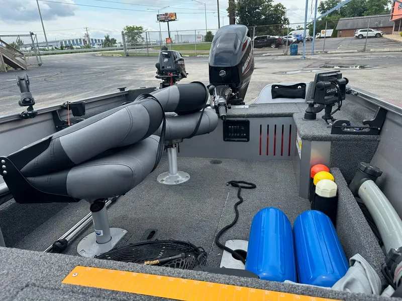 Slide: The Image of 2020 Crestliner 1450 Discovery Tiller boat interior with seats, motor, and equipment. - 2