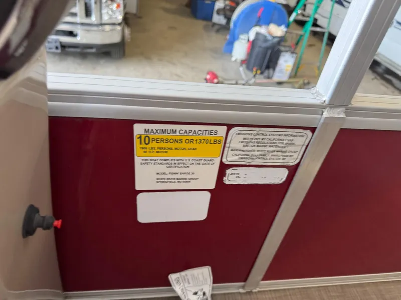 Slide: The Image of Capacity label on 2021 Sun Tracker Fishin' Barge 20 DLX, showing 10-person or 1370 lbs limit. - 12