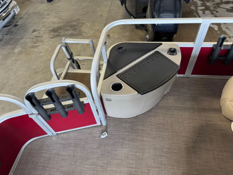 Slide: The Image of 2021 Sun Tracker Fishin' Barge 20 DLX interior with rod holders and storage compartment. - 17