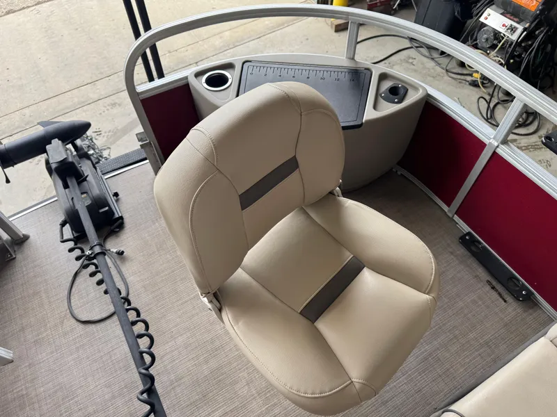 Slide: The Image of 2021 Sun Tracker Fishin' Barge 20 DLX boat interior with beige seating and control panel. - 8