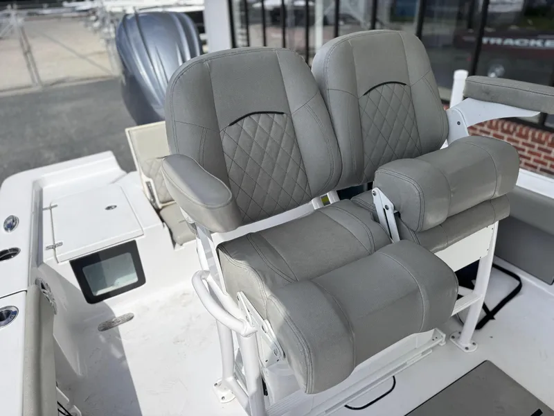 Slide: The Image of 2024 Sportsman Masters 247OE Bay Boat with dual gray captain's chairs and armrests. - 10
