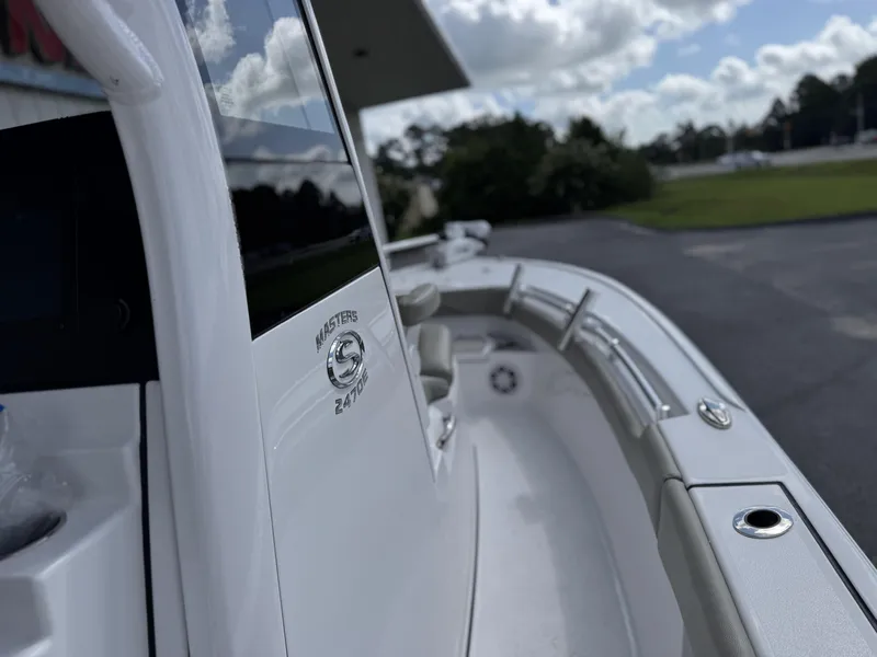 Slide: The Image of 2024 Sportsman Masters 247OE Bay Boat, sleek design, white exterior, outdoor setting. - 14