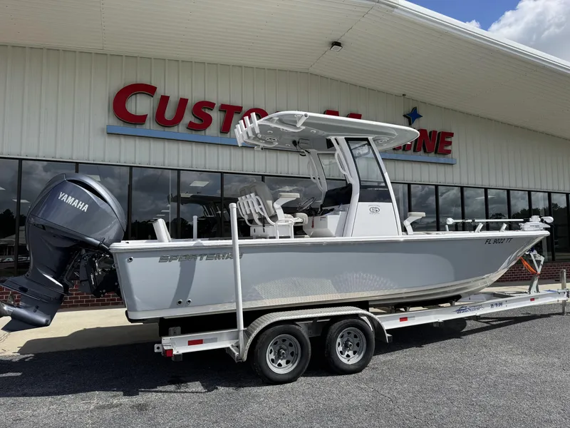 Slide: The Image of 2024 Sportsman Masters 247OE Bay Boat on trailer outside dealership, featuring Yamaha engine. - 2