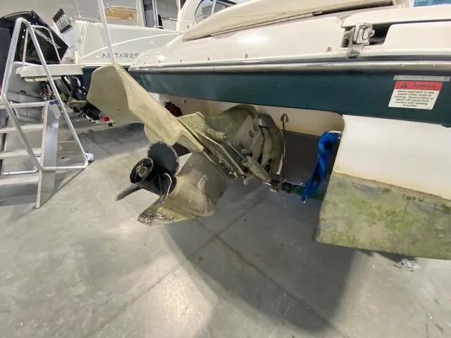 Slide: The Image of 2000 Four Winns 200 Horizon boat with visible propeller and stern in a garage. - 4