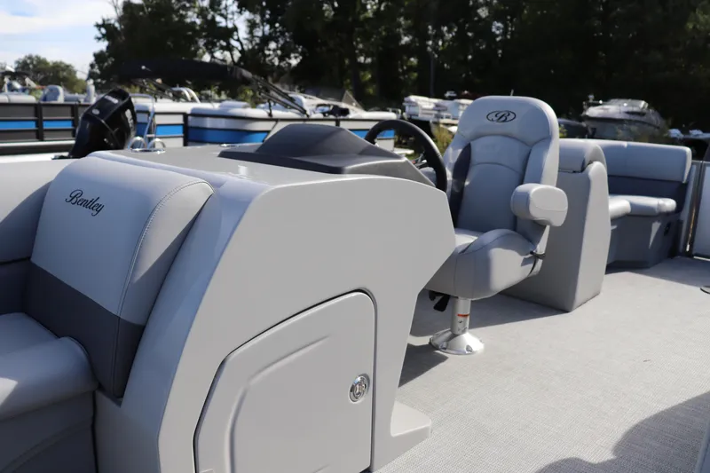 Slide: The Image of 2025 Bentley Pontoons 220 Navigator interior with sleek gray seating and modern dashboard. - 2
