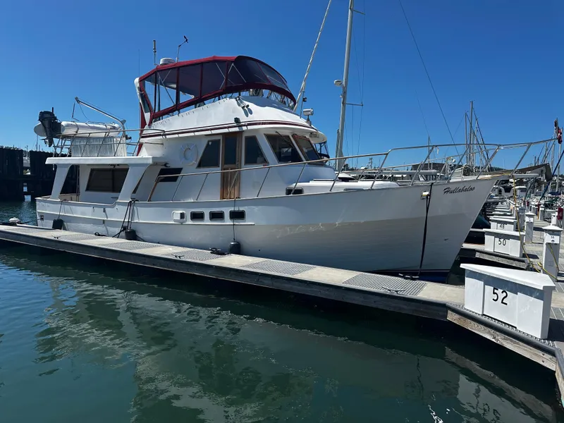 Slide: The Image of 1986 Sea Ranger 47 Pilothouse yacht docked at marina under clear blue sky. - 2