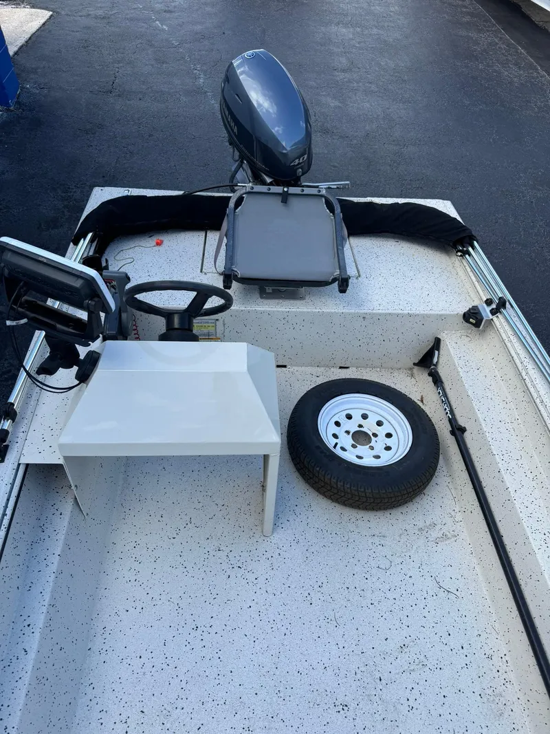 Slide: The Image of 2016 Xpress HD16DB boat interior with steering wheel, spare tire, and motor. - 10