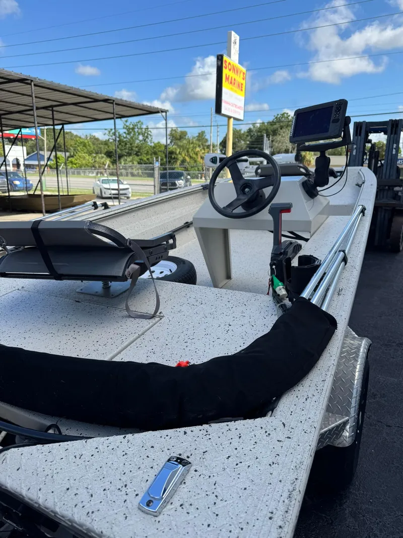 Slide: The Image of 2016 Xpress HD16DB boat with steering console and electronics, parked outdoors under blue sky. - 5
