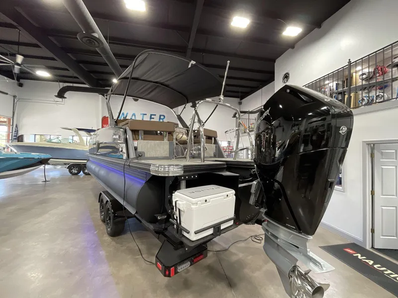 Slide: The Image of 2025 Balise Horizon 26C boat in showroom, featuring powerful outboard motor and sleek design. - 3