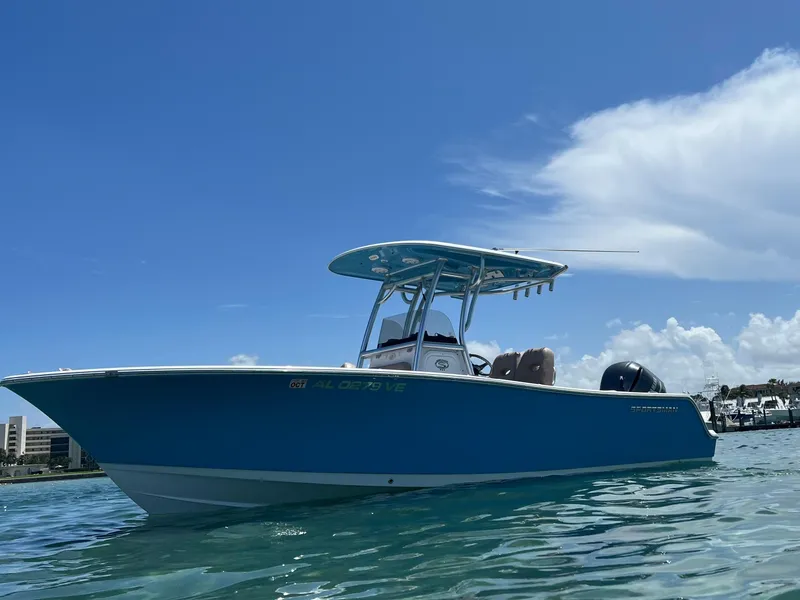 Slide: The Image of 2019 Sportsman Heritage 241 Center Console boat on clear water under blue sky. - 1