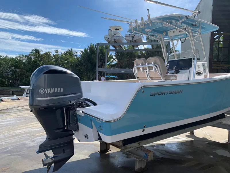 Slide: The Image of 2019 Sportsman Heritage 241 Center Console boat with Yamaha engine, docked outdoors. - 2