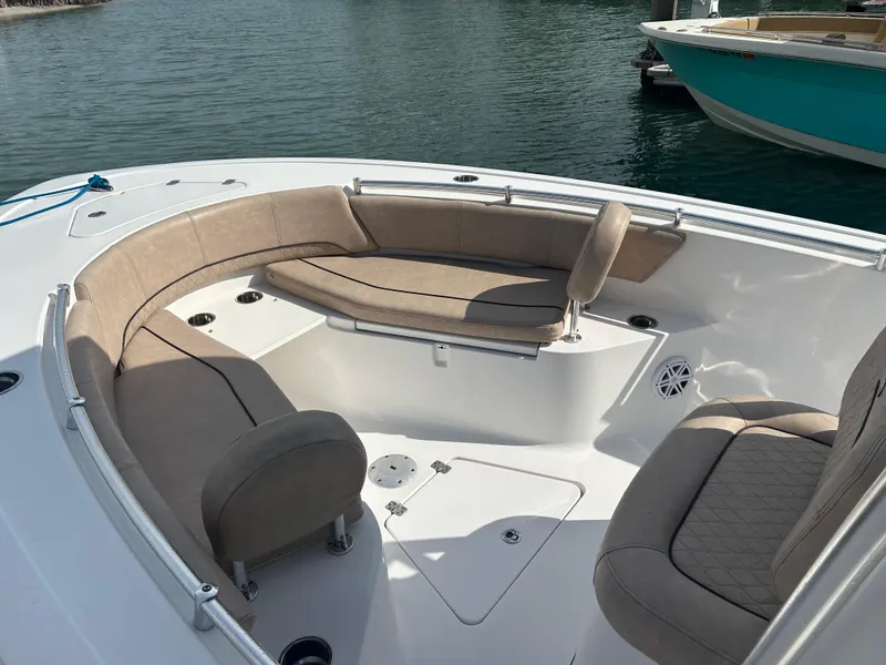 Slide: The Image of 2019 Sportsman Heritage 241 Center Console boat with beige seating, docked on calm water. - 4