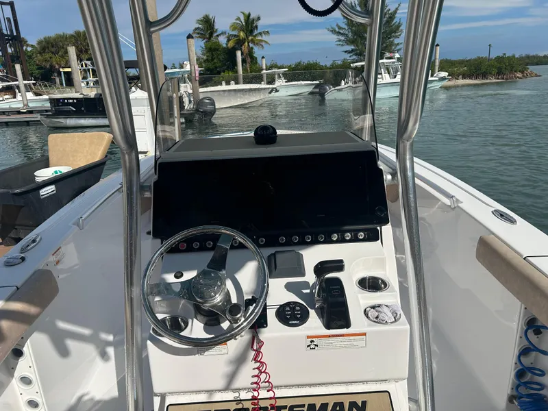 Slide: The Image of 2019 Sportsman Heritage 241 Center Console boat dashboard with steering wheel and controls. - 7