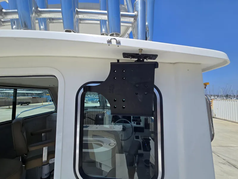 Slide: The Image of 2019 Parker 2520 DV boat cabin with window and metal fixtures, dockside view. - 10