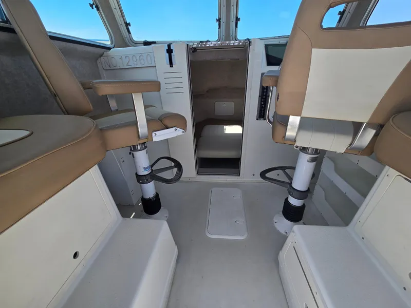 Slide: The Image of Interior of a 2019 Parker 2520 DV boat with tan seating and control panel. - 19