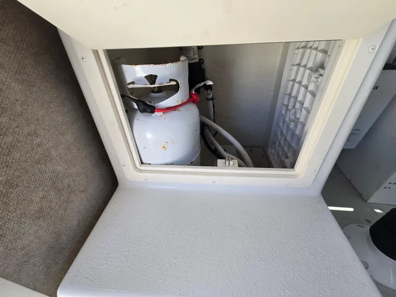 Slide: The Image of Propane tank storage compartment in a 2019 Parker 2520 DV boat. - 22