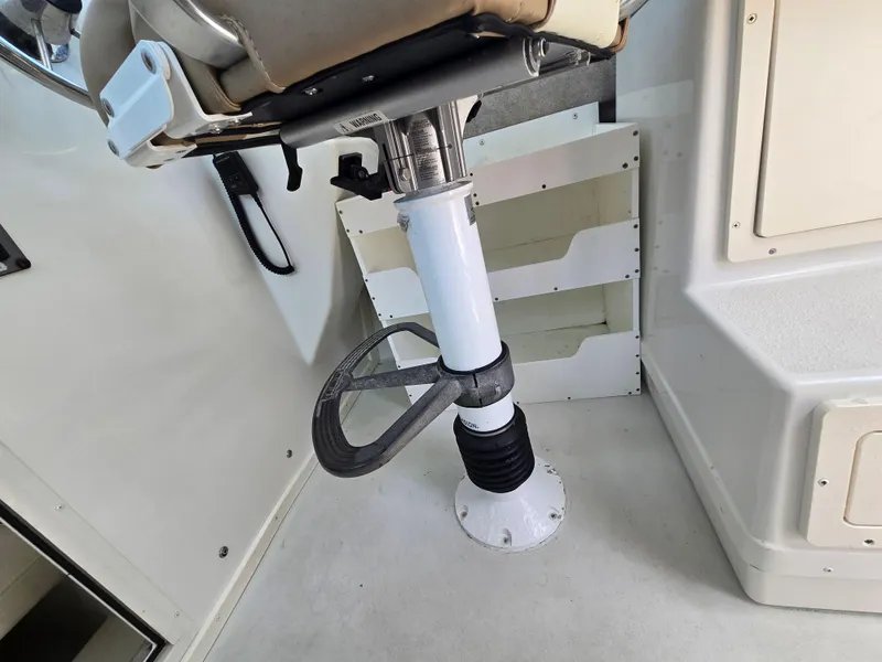 Slide: The Image of Interior of a 2019 Parker 2520 DV boat showing a seat pedestal and storage area. - 25