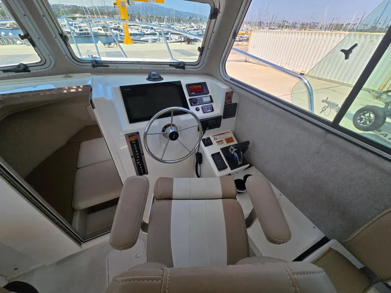 Slide: The Image of Interior of a 2019 Parker 2520 DV boat, featuring steering wheel and control panel. - 26