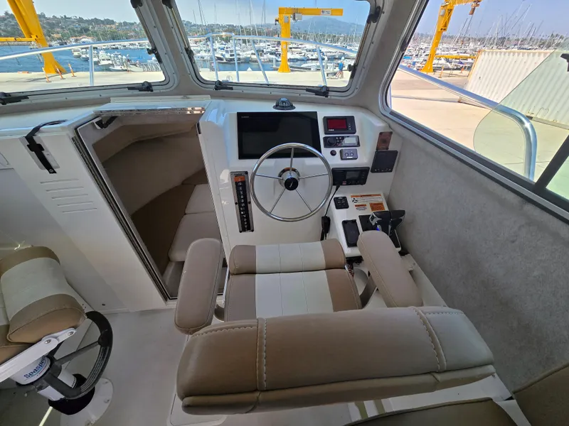Slide: The Image of Interior of a 2019 Parker 2520 DV boat with steering wheel and control panel. - 27