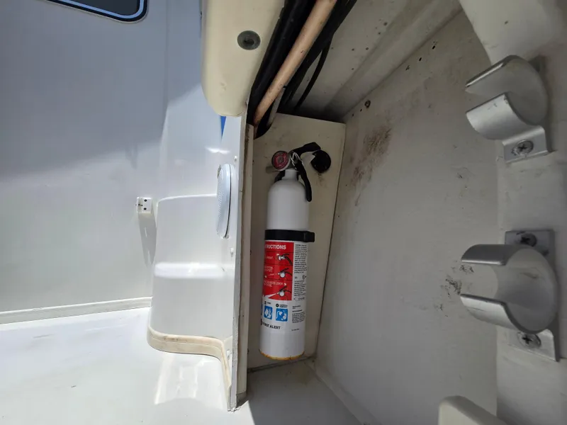 Slide: The Image of Fire extinguisher mounted on a 2019 Parker 2520 DV boat interior. - 29