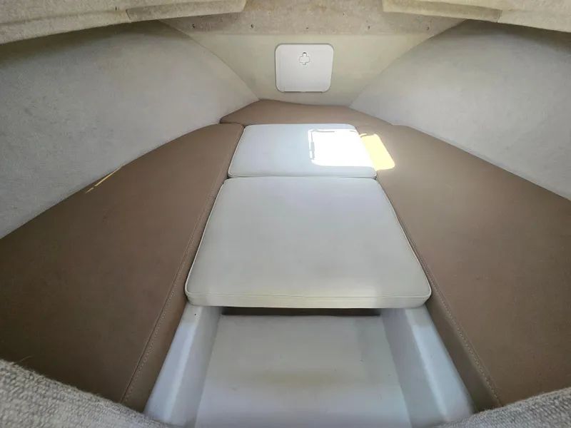 Slide: The Image of 2019 Parker 2520 DV boat cabin interior with cushioned seating and storage compartment. - 30