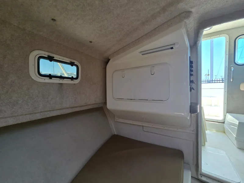 Slide: The Image of Interior cabin of 2019 Parker 2520 DV boat with window and seating area. - 33