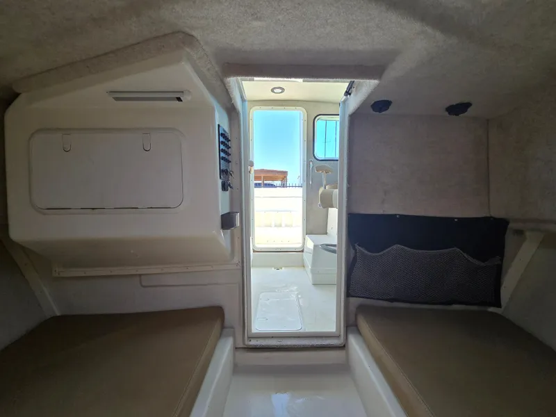 Slide: The Image of Interior view of 2019 Parker 2520 DV boat cabin with seating and storage. - 35